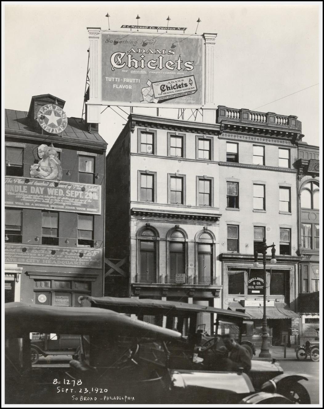 A black and white photo of a building with a sign on it
Description automatically generated with low confidence